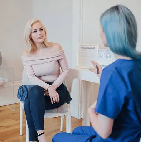 Patient sitting with a nurse in a bright consultation room at Cool Clinic, CoolSculpting fat freezing Amsterdam