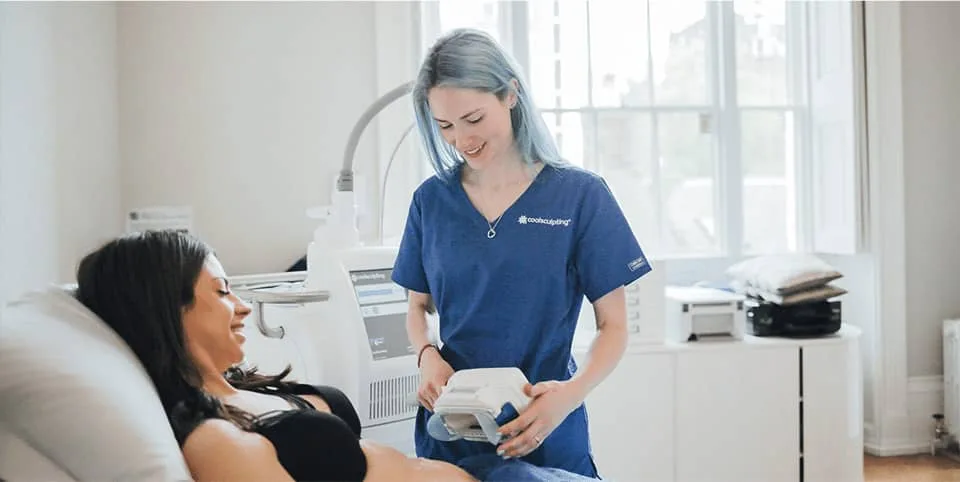 Nurse preparing a fat freezing device beside a patient on a couch at Cool Clinic, CoolSculpting fat freezing Amsterdam